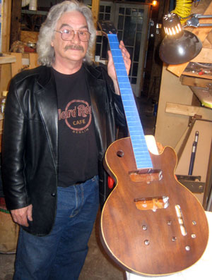 Chuck Burge in his workshop with a stripped down Les Paul bass