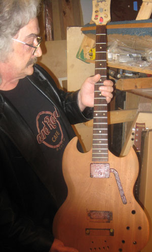 Chuck Burge in his workshop with a stripped down late sixties EB3 bass